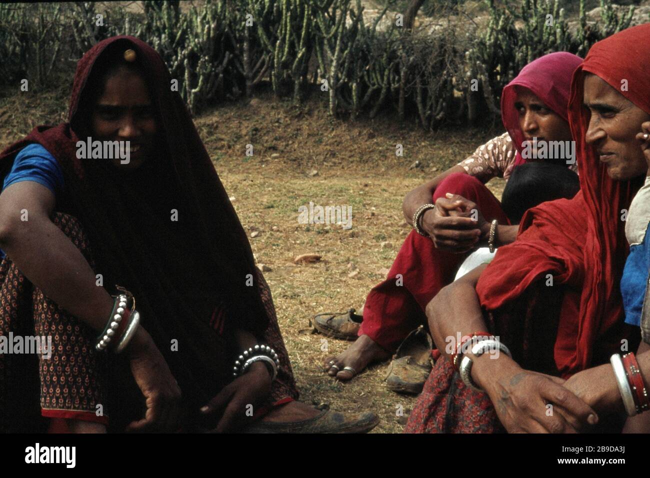 Women in red robes sit at the roadside near Kokus. [automated translation] Stock Photo