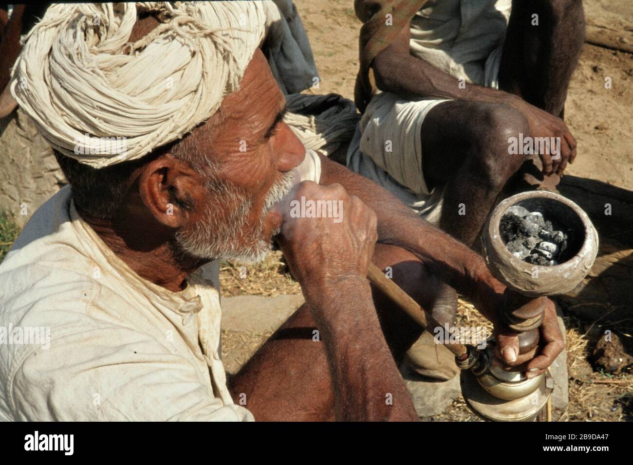 An elderly man smokes a traditional pipe in Kokus. [automated translation] Stock Photo