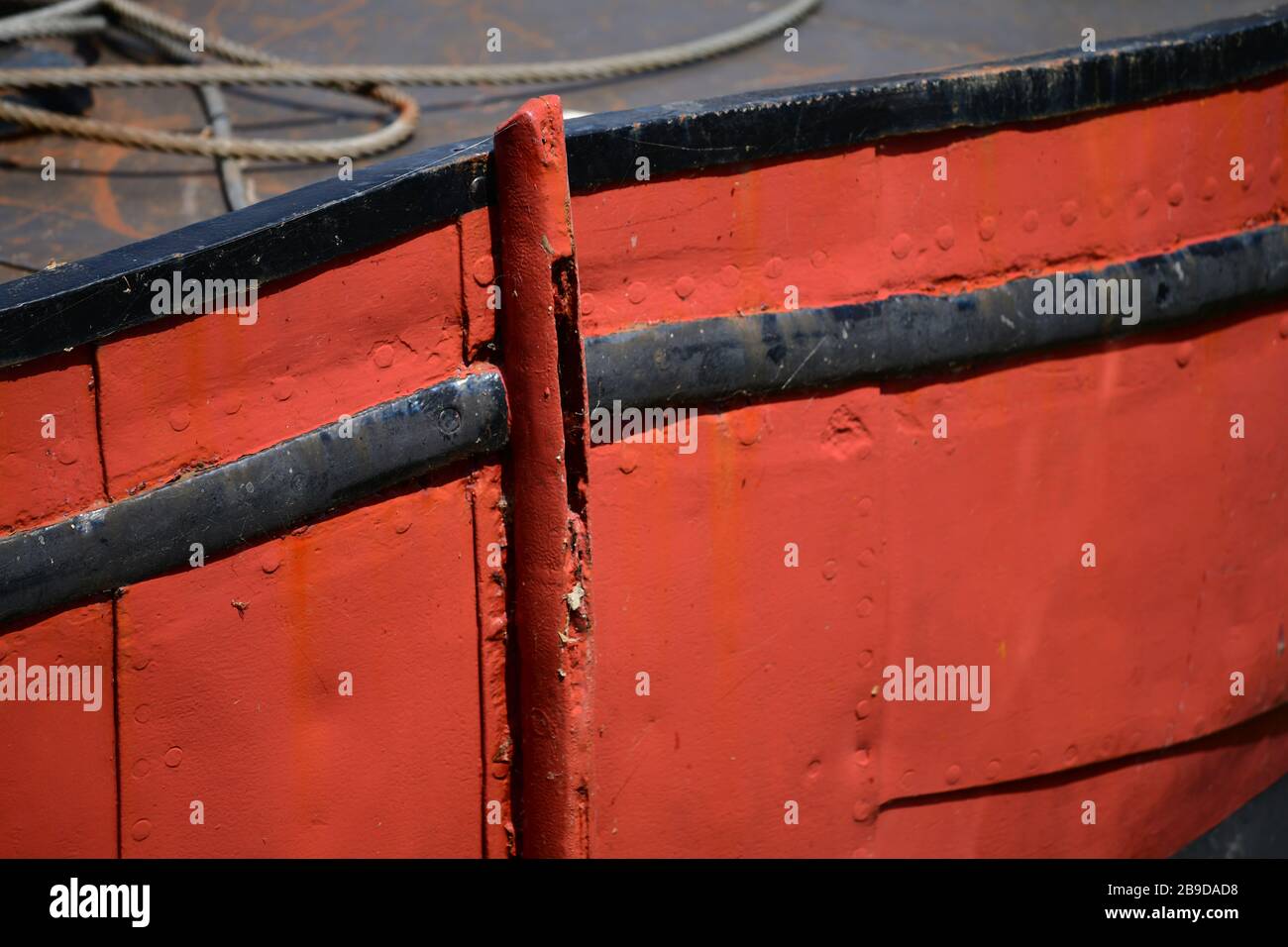 Close up of weathered bright red part of bow of an historic flat bottom boat in the Oude Haven in Rotterdam, the Netherlands Stock Photo