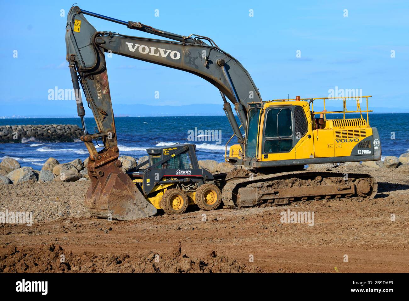 Yellow Earth Moving Front End Digger Playing with a Smaller Yellow Friend for Security Purposes Stock Photo