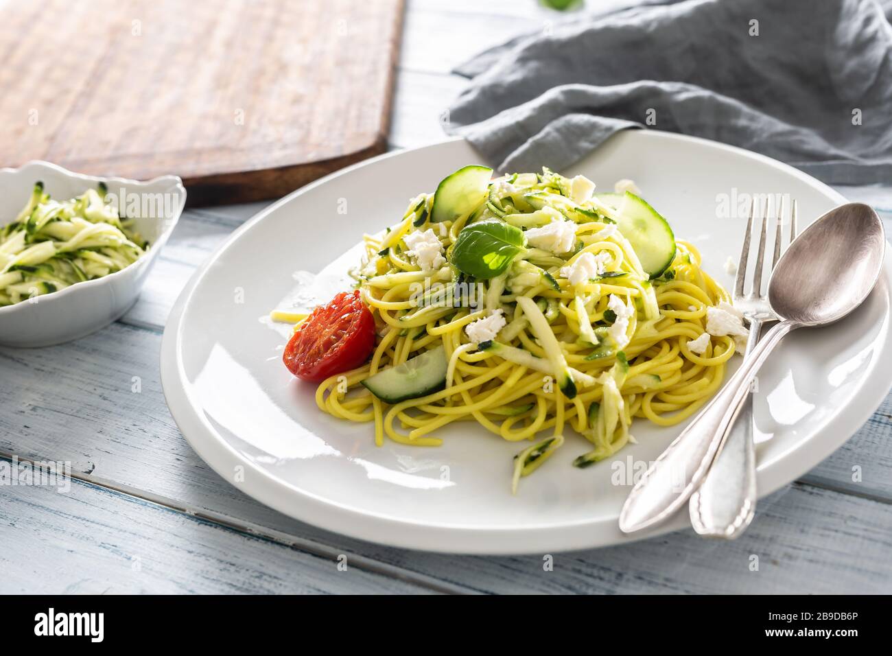 Spaghetti zucchini raw vegan pasta with feta cheese cucumber and basil Stock Photo