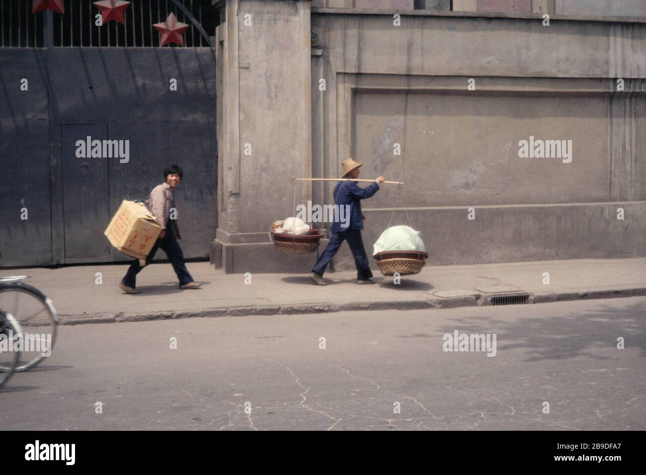 Two passers-by are carrying groceries on a curb in Wuhan. [automated translation] Stock Photo