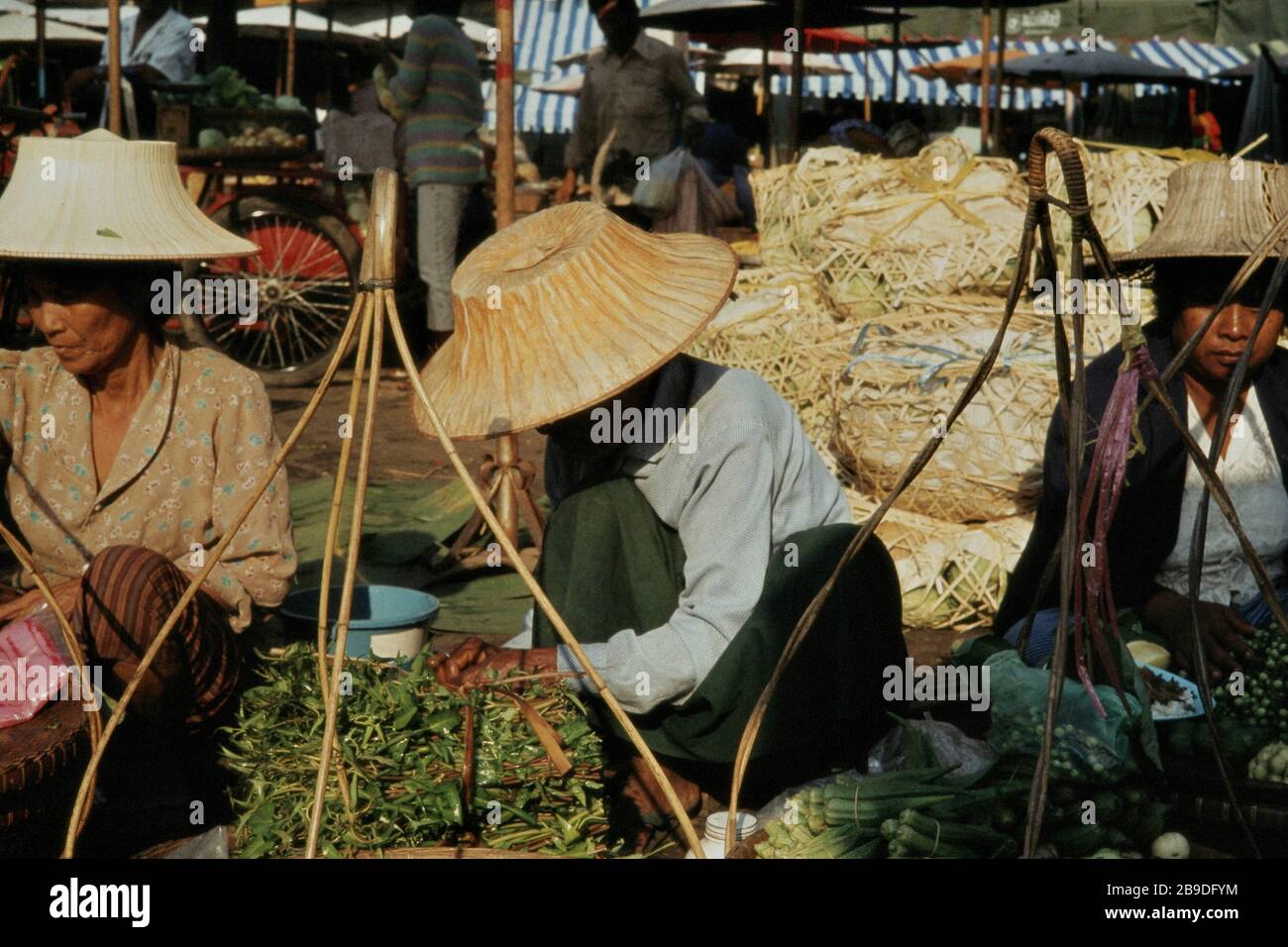 Vegetable sellers with straw hats on a morning market place in Nakhon