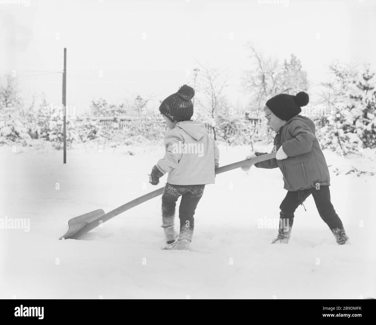 Children playing in the snow with a large snow shovel (undated picture