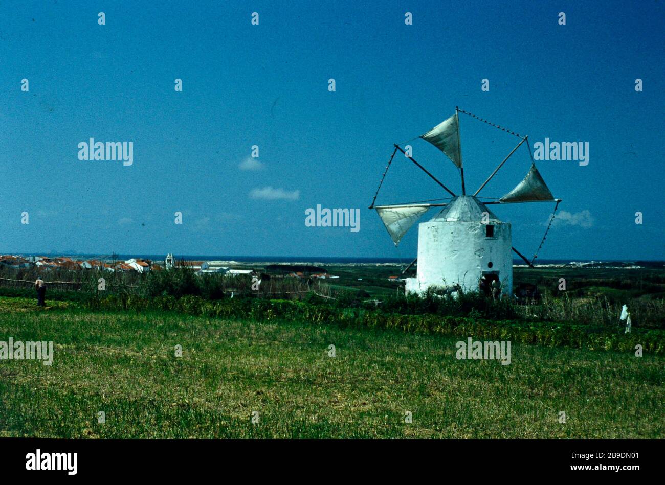 A white windmill in the country. In the background you can see a place