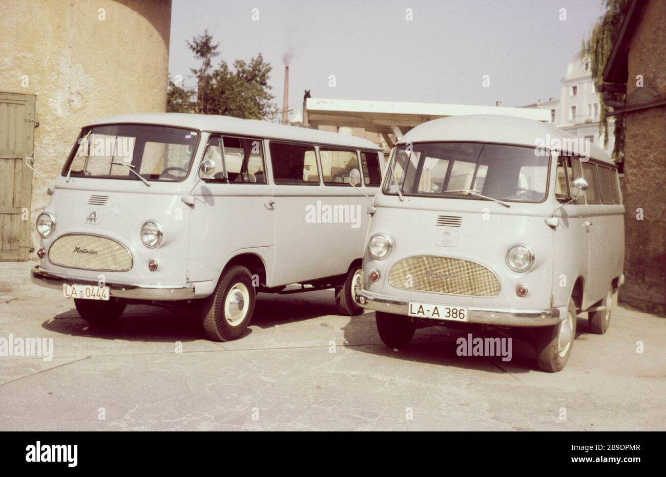 Two small vans of the types Hanomag Matador E and Tempo Matador E with  Landshut registration number and in light-coloured paintwork stand in a  yard. To the left and right the yard