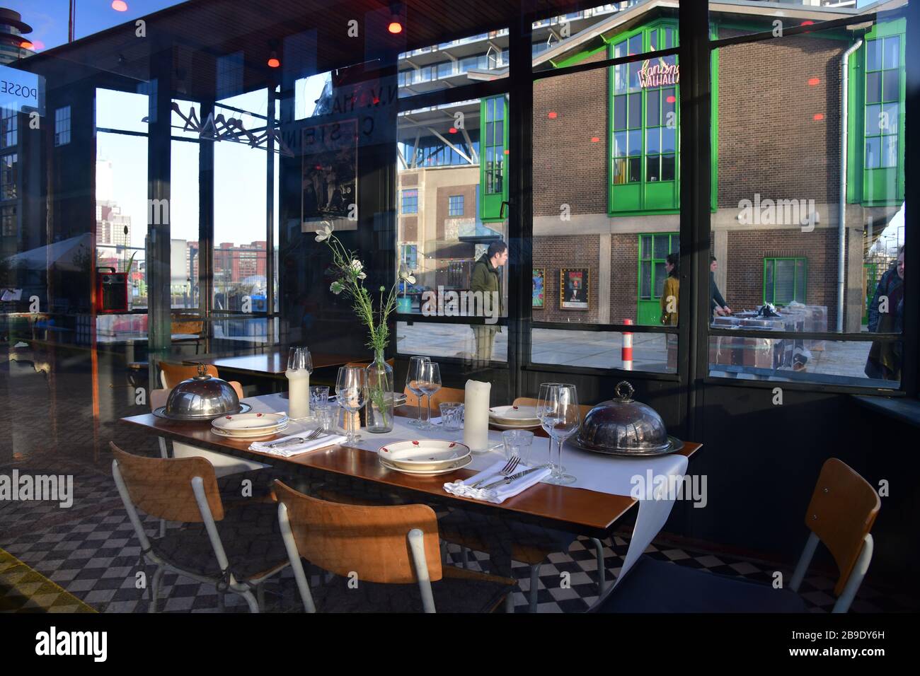 Table set up with dinnerware inside the private building with large windows of Posse in Katendrecht Rotterdam Stock Photo