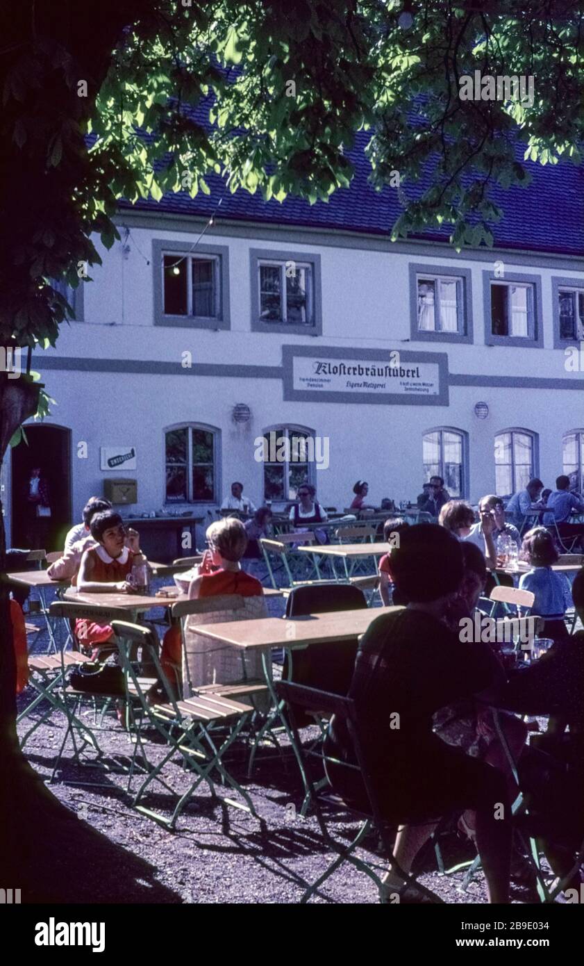 Some people enjoy the sun in the beer garden of the Klosterbräustüberl