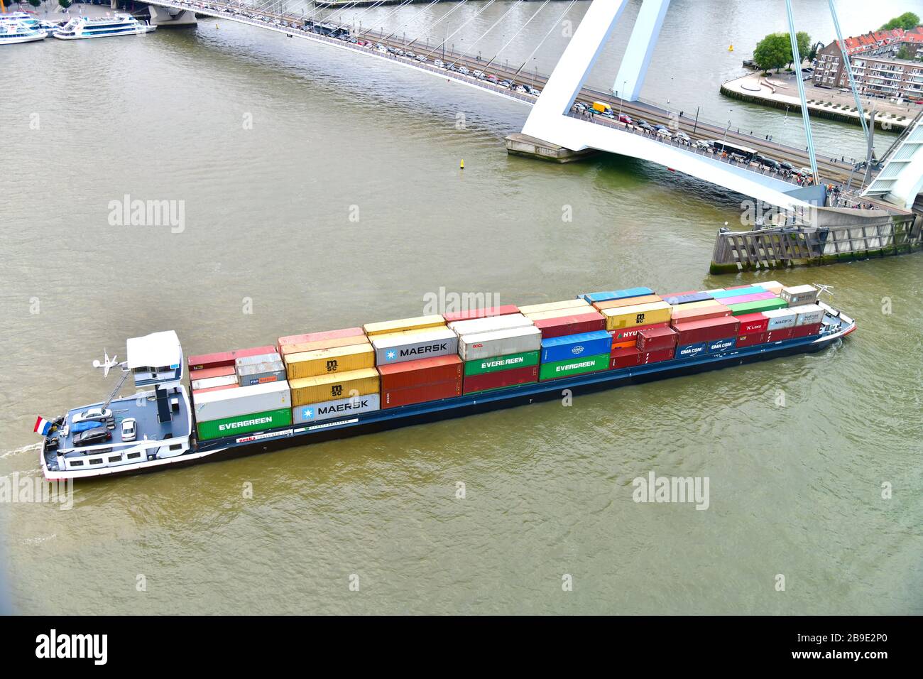 Birdseye view of container barge making its way through the open bridge of the Erasmusbrug in Rotterdam stopping traffic with Noordereiland Stock Photo