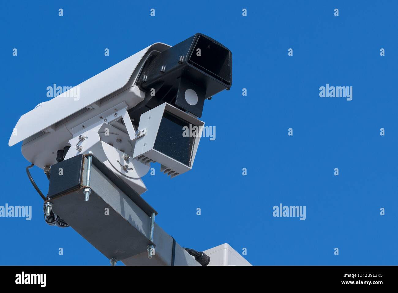 Isolated speed control camera with a radar, close-up, blue sky background, front view, free space for text. Stock Photo