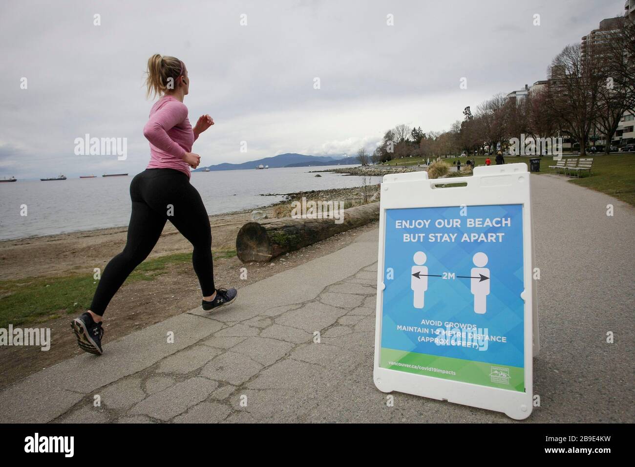 Vancouver, Canada. 23rd Mar, 2020. A sign reminds people to keep two metre social distance is placed at English Bay in Vancouver, Canada, March 23, 2020. Canadian Prime Minister Justin Trudeau announced Monday that his government will allot 192 million Canadian dollars (132 million U.S. dollars) on the development and production of vaccines and treatments against COVID-19. Credit: Liang Sen/Xinhua/Alamy Live News Stock Photo