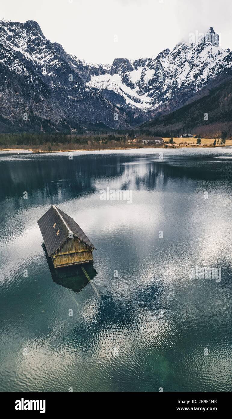 Traditional wooden boathouse reflecting on the crystal clear water of the Almsee, near Grünau im Almtal, Oberösterreich, Austria Stock Photo