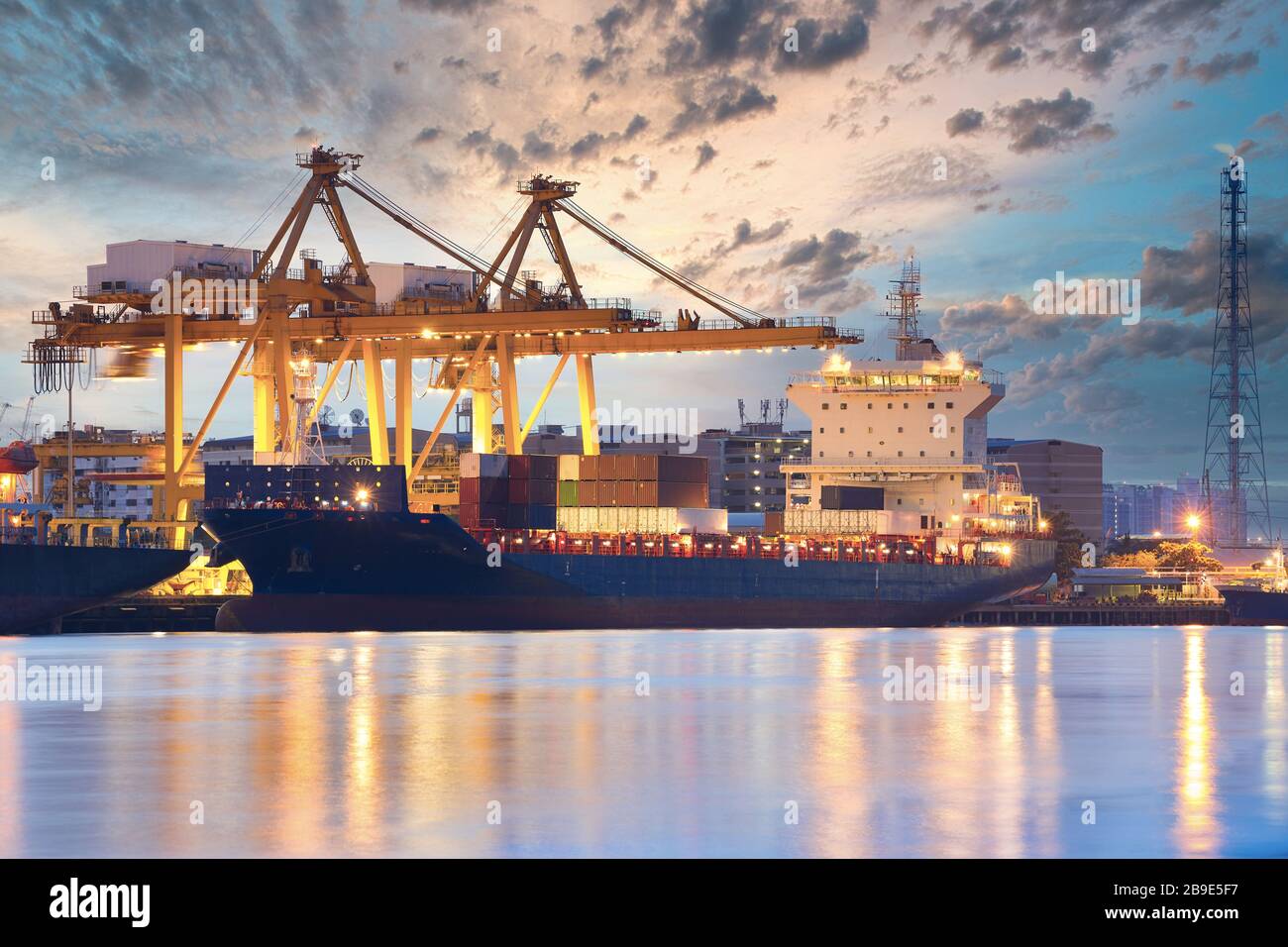 Background for cranes and industrial cargo ships in port at twilight ...