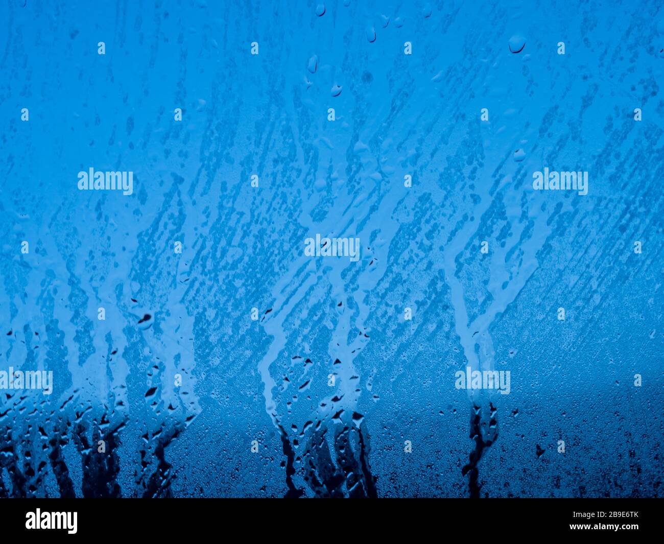 Condensation water drop on the blue glass window. Rain. Abstract background texture. Stock Photo