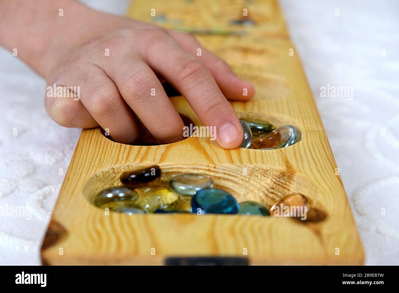 playing mancala at home, mancala intelligence game on carpet, Stock Photo