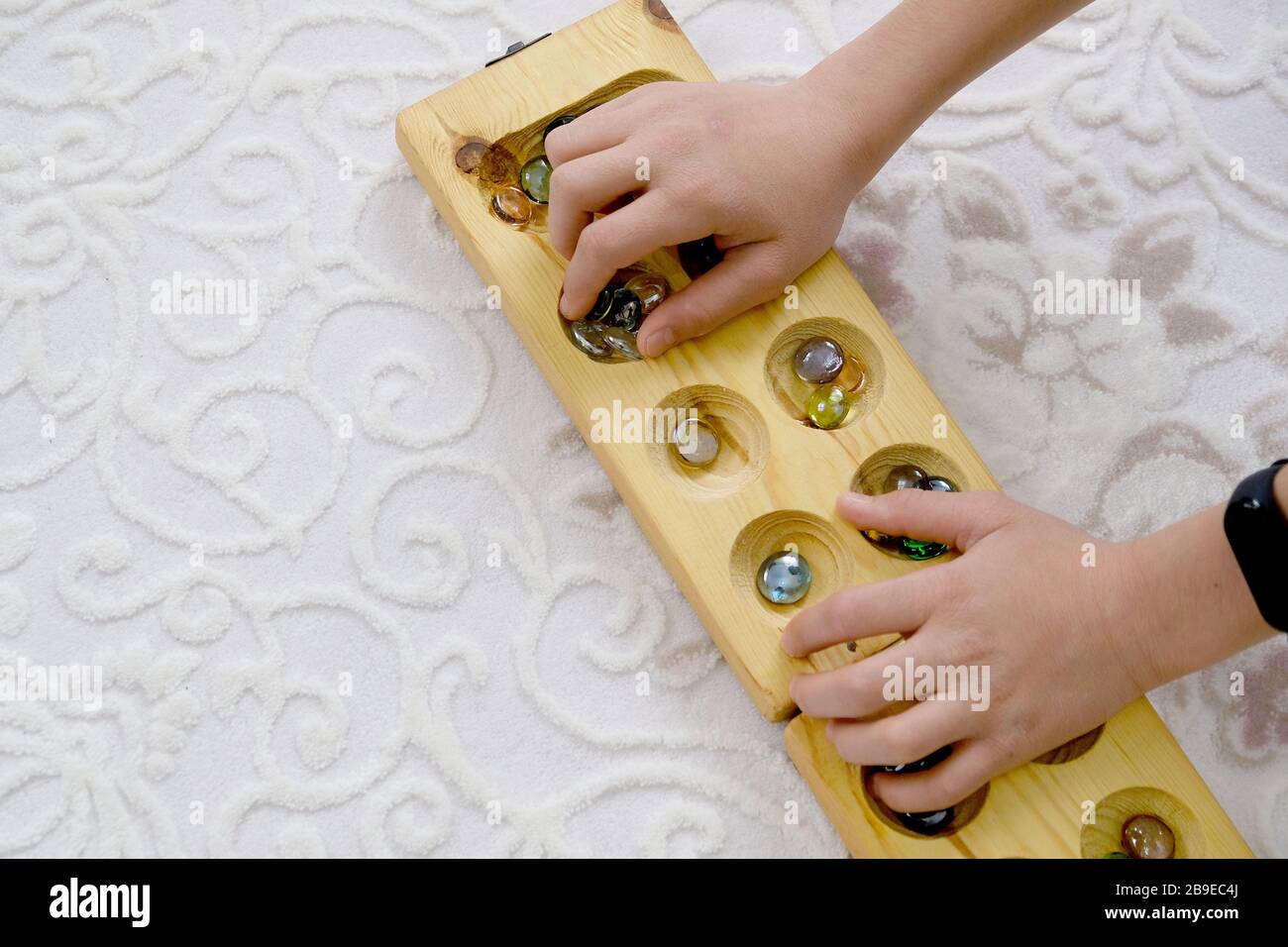 old intelligence games, wooden mancala game, a person playing mancala,play mancala, intelligence game mancala, middle east intelligence game mancala, Stock Photo