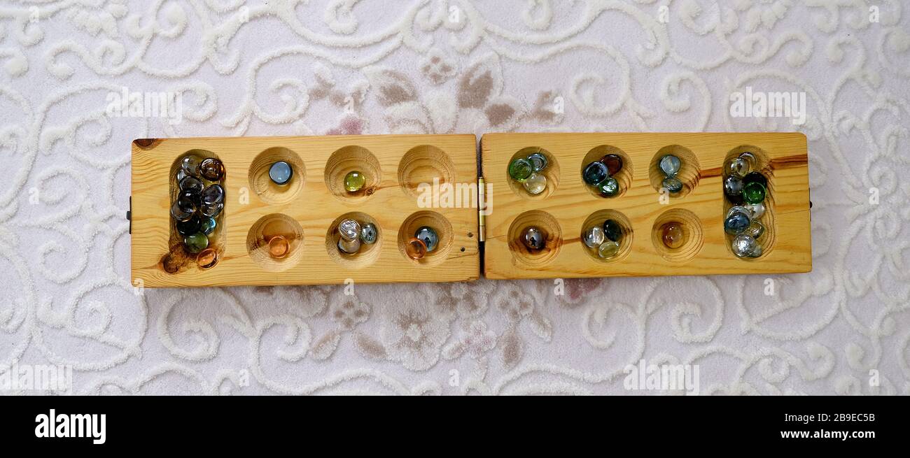 old intelligence games, wooden mancala game, a person playing mancala, Stock Photo