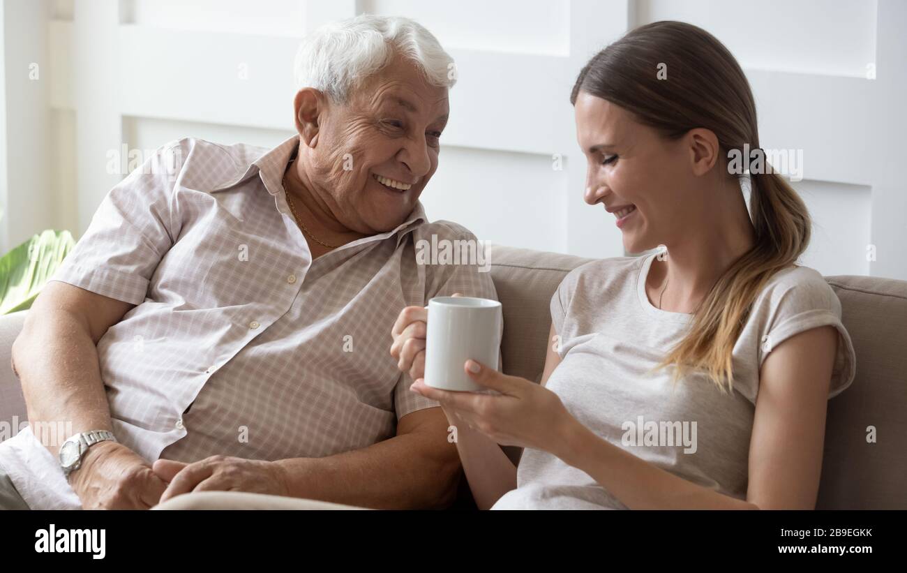 Happy older father and adult daughter chatting, having fun together Stock Photo