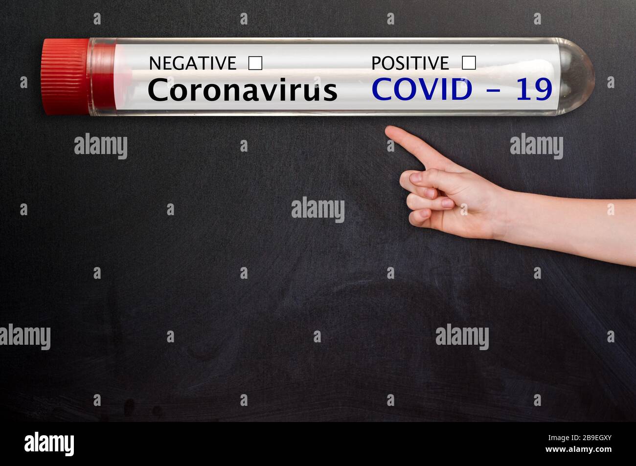 Coronavirus blood test tube and Blackboard / chalkboard. On table Hand with copyspace - empty space for text. Stock Photo