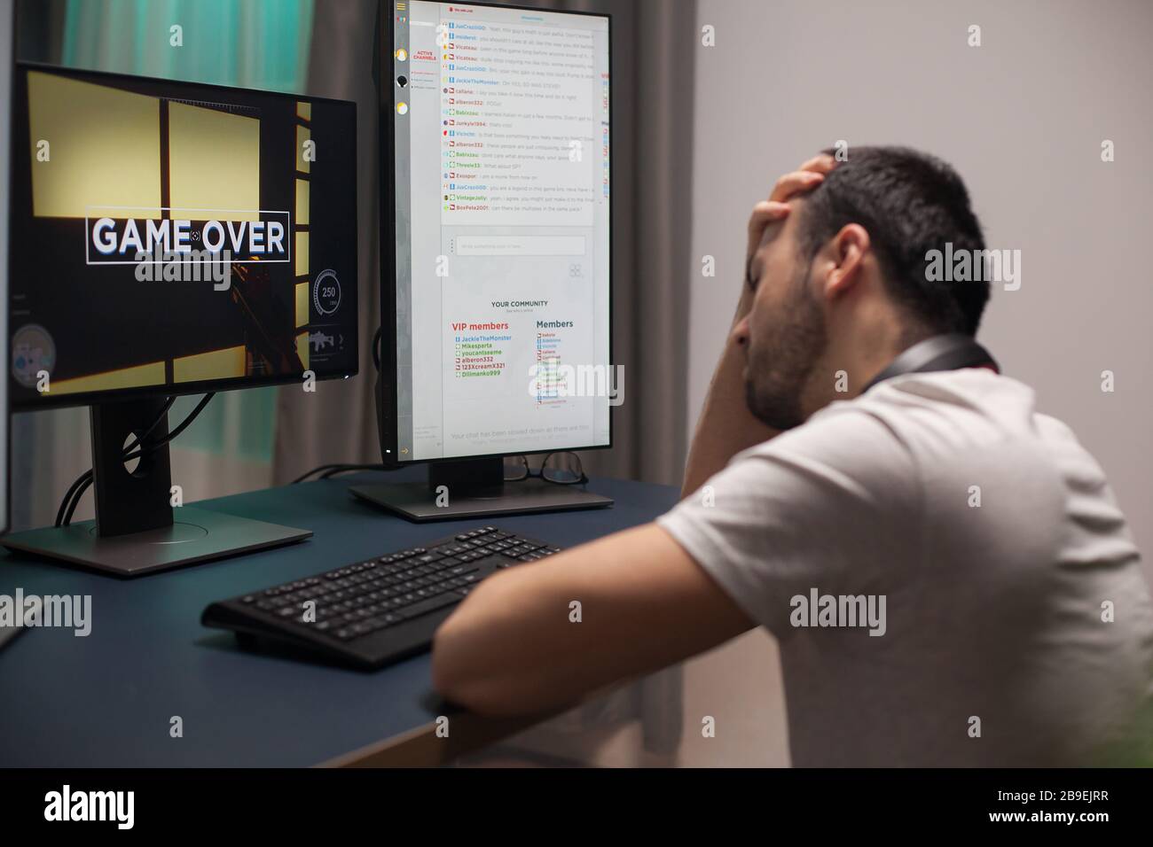 Man covering his face after game over while playing online shooter