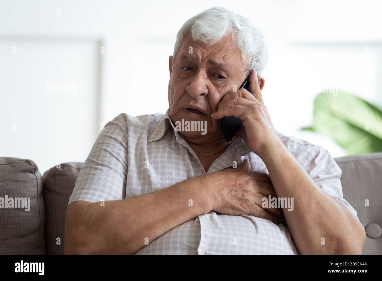 Upset older man touching chest, calling emergency, heart attack Stock Photo