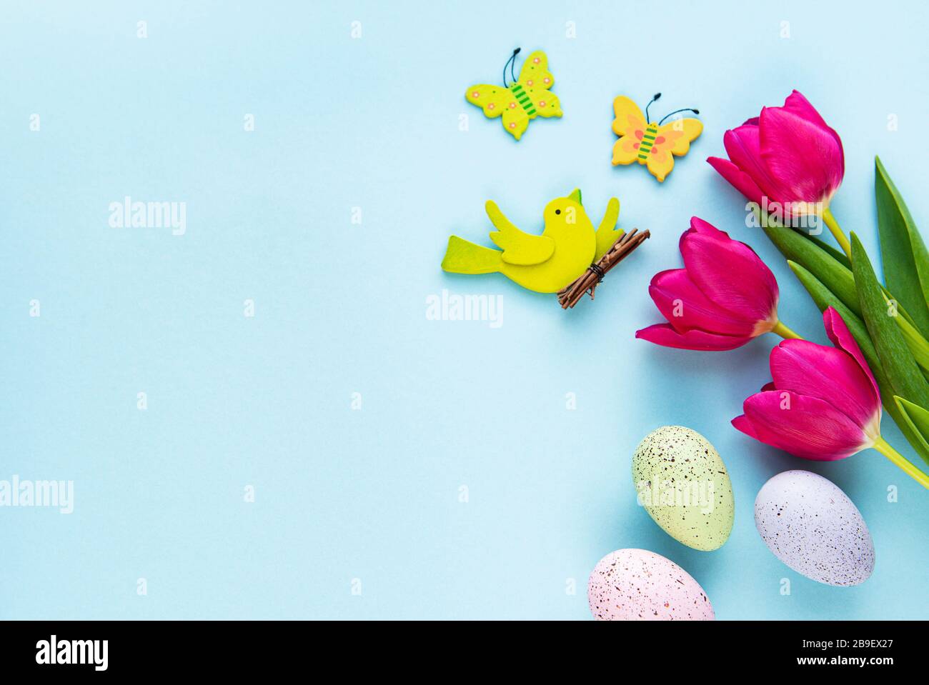 Spring tulips and Easter eggs on a pastel blue background Stock Photo ...