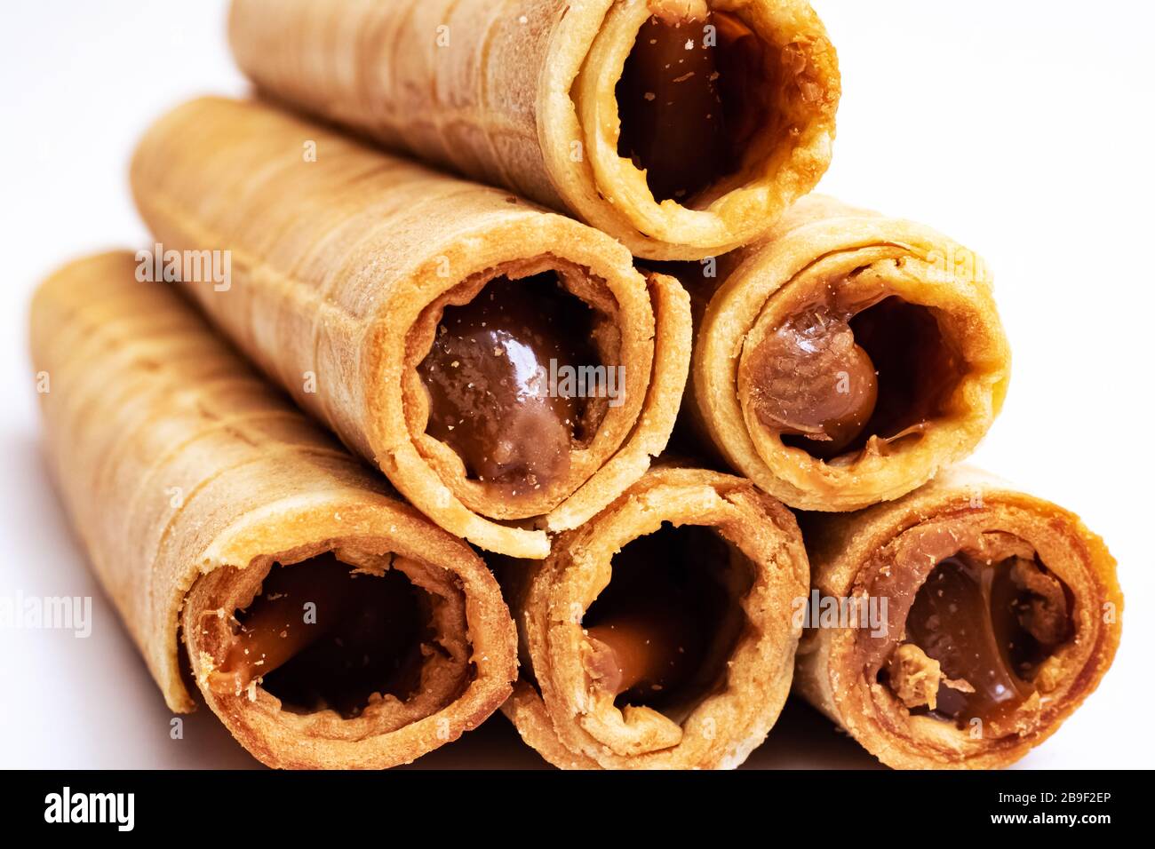 Wafer rolls with condensed milk on white background Stock Photo