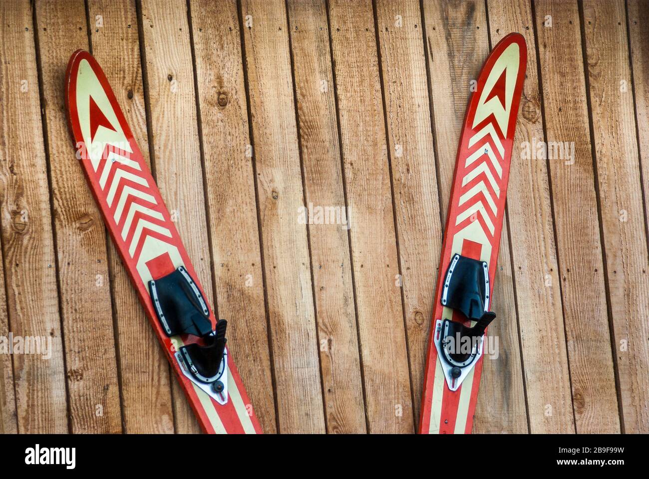 a pair of water skis hung on a board wall and nailed, attached to the nail, ein Paar Wasserski an eine Bretterwand aufgehängt und genagelt, an den Nag Stock Photo