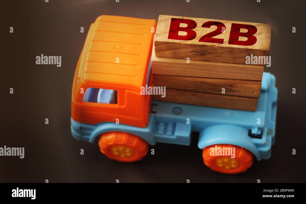 Toy truck hold letter block in word B2B abbreviation of business to business on black background. Business B2B logistic concept Stock Photo