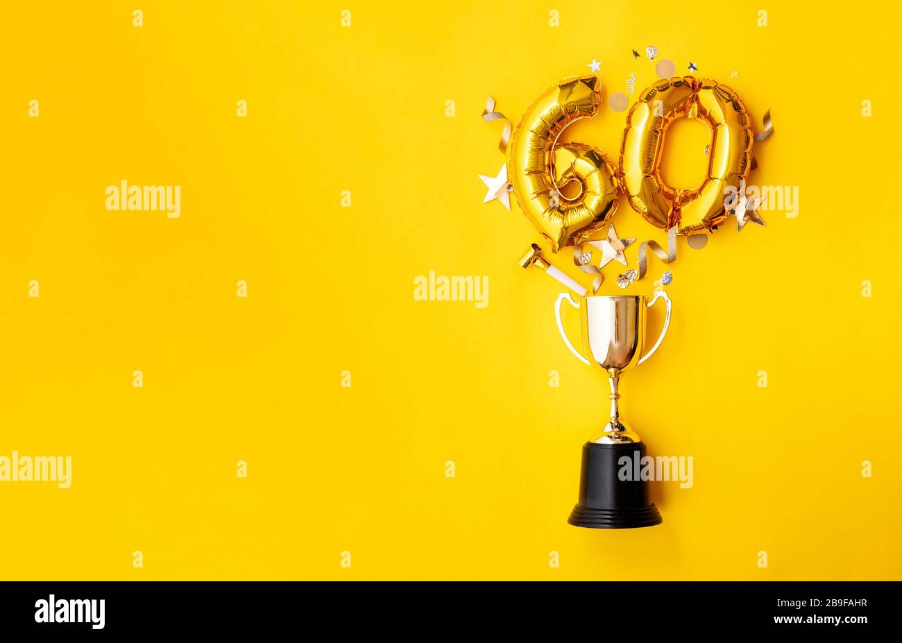 Number 60 gold anniversary celebration balloon exploding from a winning trophy Stock Photo