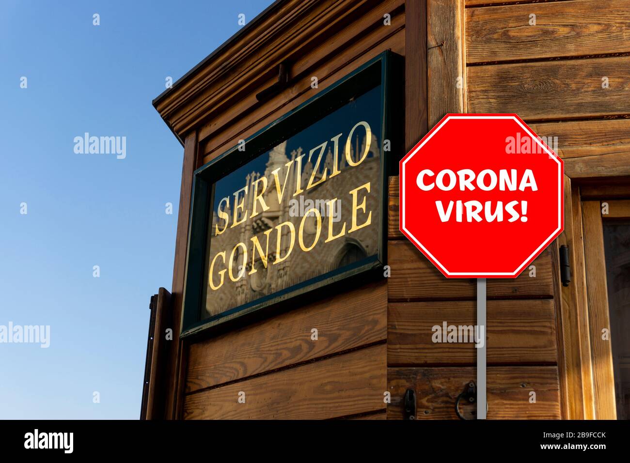 View of the wooden bulding of the Servizio Gondole in Venice with a stop sign that says Corona Virus! Stock Photo
