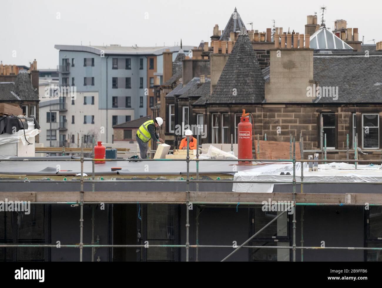 Construction workers on the Sunnybank site where new apartments are being built on Lower London Road, Edinburgh, the day after Prime Minister Boris Johnson put the UK in lockdown to help curb the spread of the coronavirus. Stock Photo