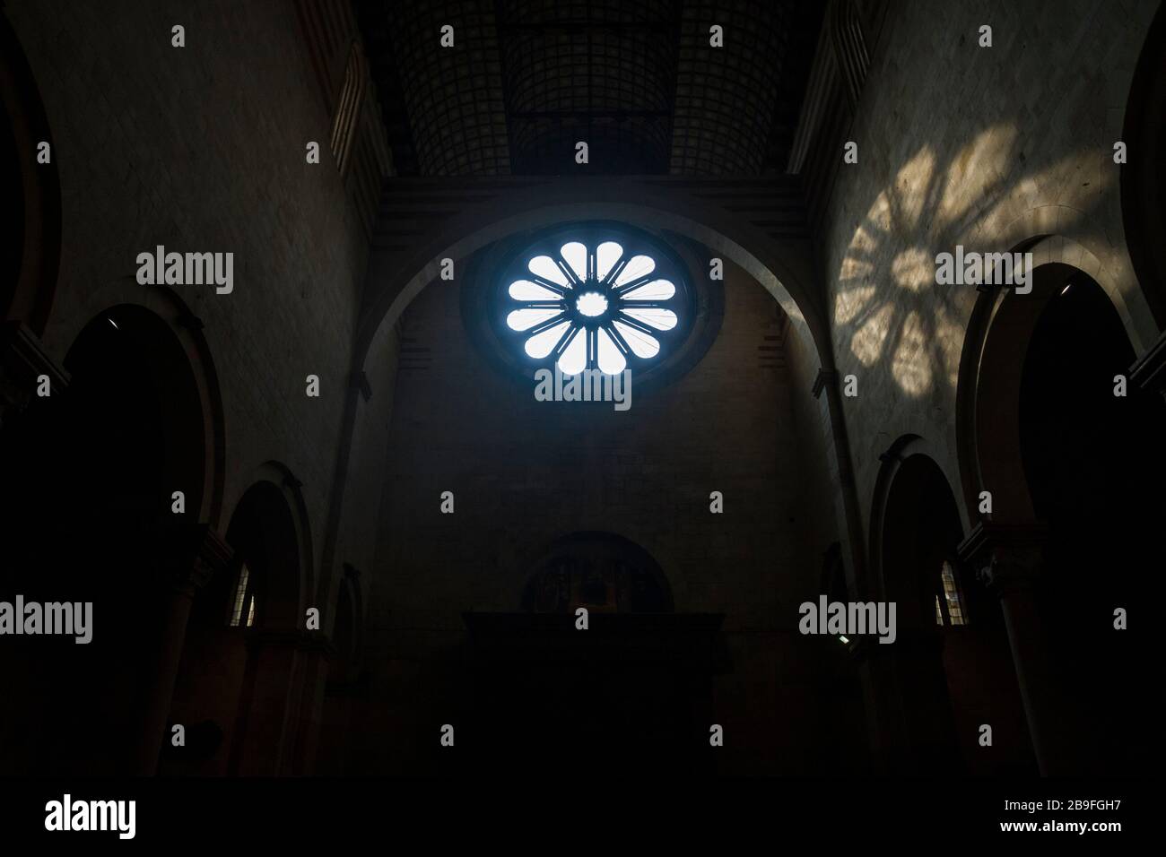 Light from the rose window falls on an interior wall inside the Basilica di San Zeno in Verona, Italy Stock Photo