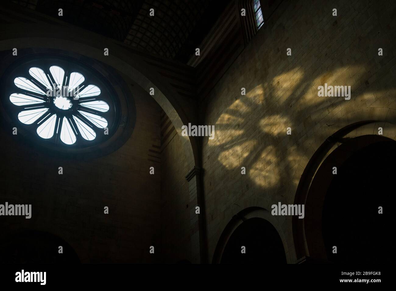 Light from the rose window falls on an interior wall inside the Basilica di San Zeno in Verona, Italy Stock Photo