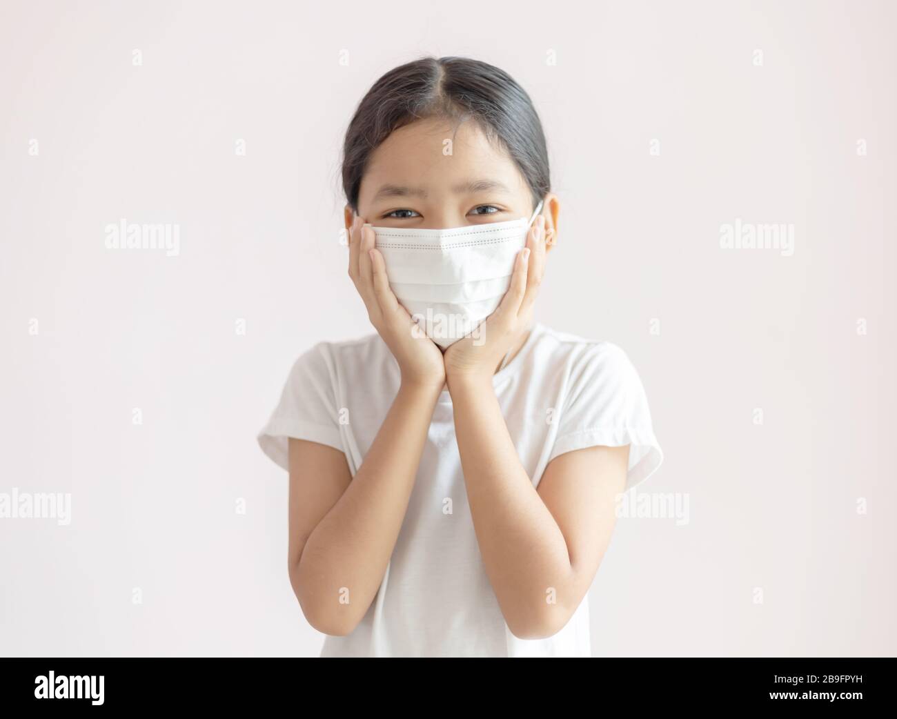 Portrait of Asian little girl wears a sanitary mask. The epidemic of the flu, Coronavirus or COVID-19 and illness. Stock Photo