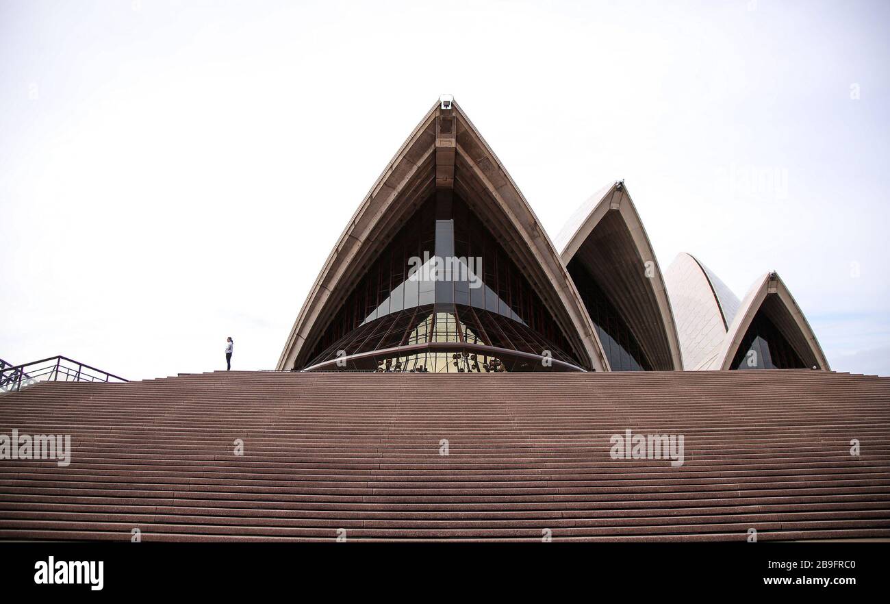 Sydney, Australia. 24th Mar, 2020. A visitor is seen near Sydney Opera House in Sydney, Australia, March 24, 2020. Australia's two largest states have decided to take significant new steps to combat the COVID-19, with both states announcing that non-essential activities and businesses will be shut down from midday Monday. The closures come as the number of confirmed cases across Australia exceed 1,609, with New South Wales and Victoria making up the bulk of infections. Credit: Bai Xuefei/Xinhua/Alamy Live News Stock Photo