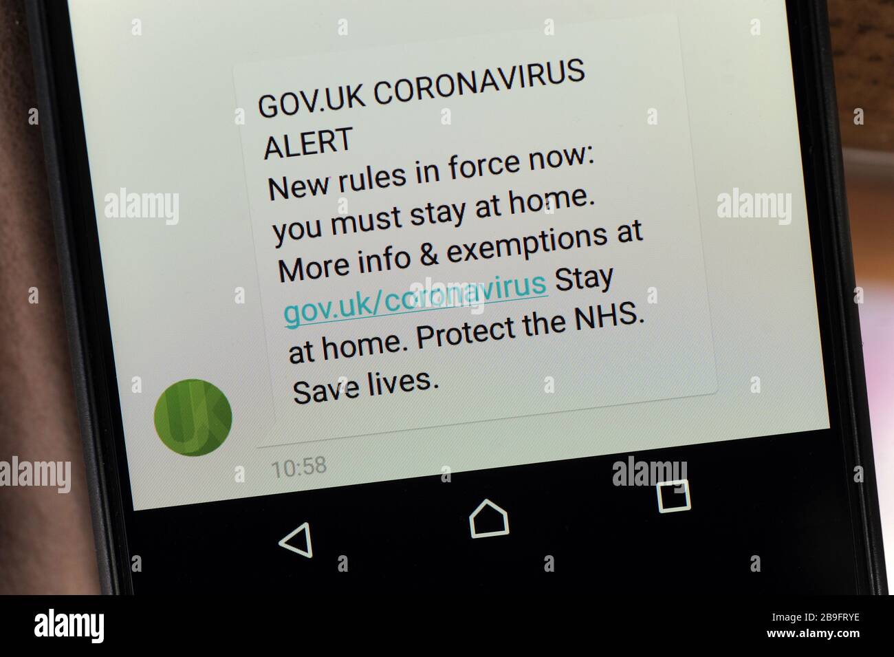 UK GOVERNMENT CORONAVIRUS ALERT MOBILE PHONE TEXT MESSAGE SAYING YOU MUST STAY AT HOME RE LOCKDOWN COVID -19 VIRUS UK Stock Photo