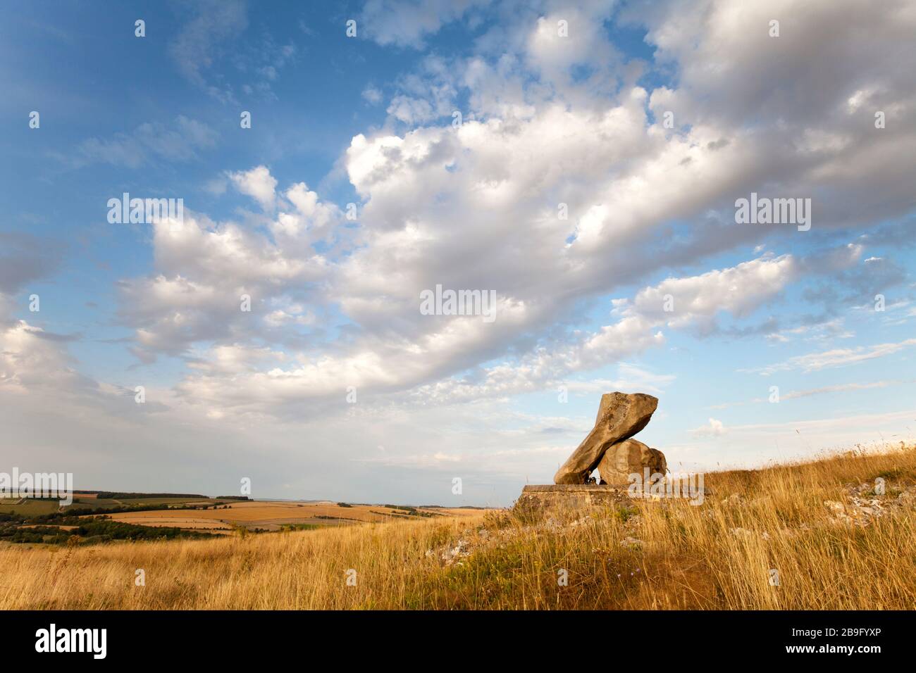 A memorial stone to the late Sir John Paskin on Ebsbury Hill, overlooking the Wylye Valley near the village of Great Wishford in Wiltshire. Stock Photo