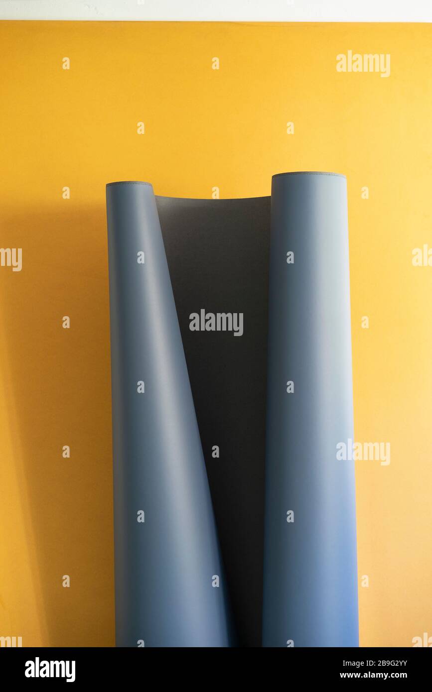 Gray sheet unrolling on yellow background Stock Photo