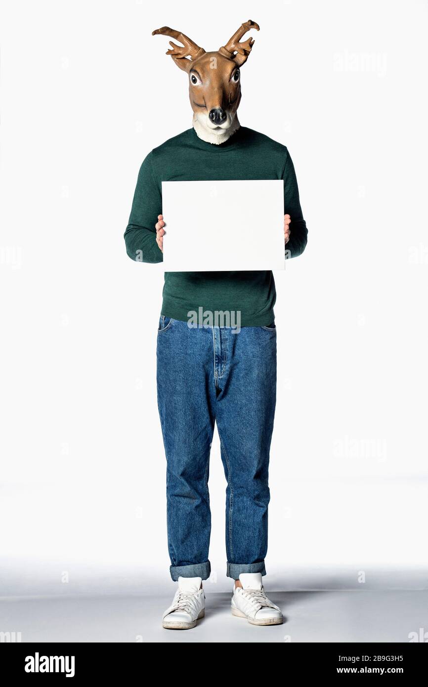 Man in reindeer mask holding blank sign Stock Photo