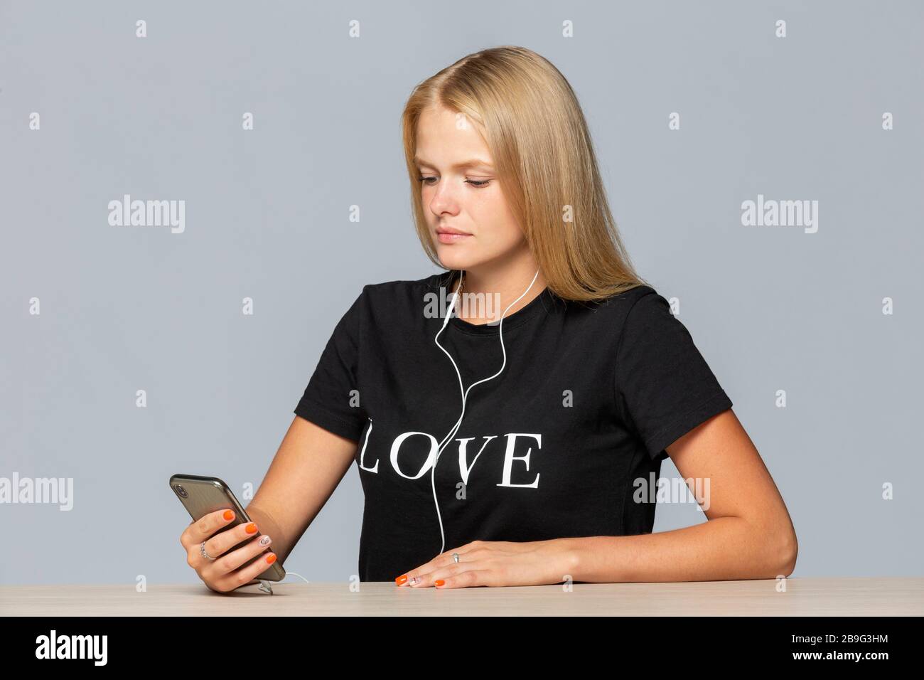 Young woman in love t-shirt listening to music with mp3 player and headphones Stock Photo