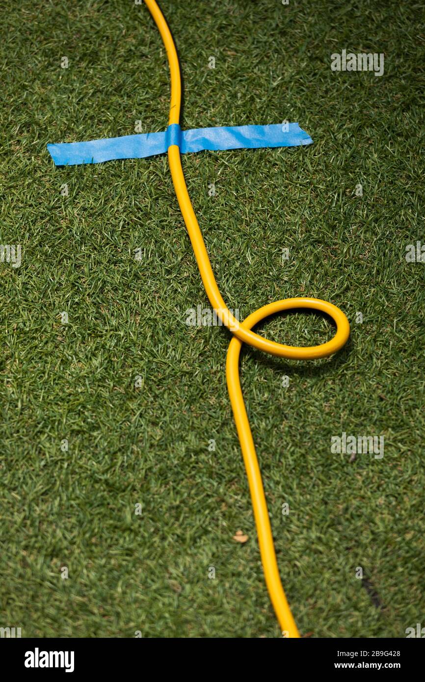 Yellow extension cord taped to grass Stock Photo Alamy