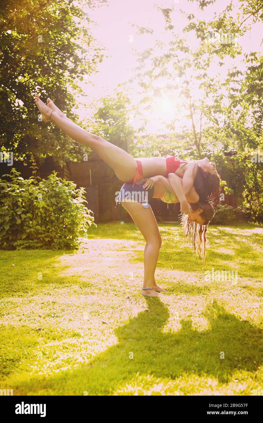 Playful teenage girl friends in sunny summer backyard Stock Photo
