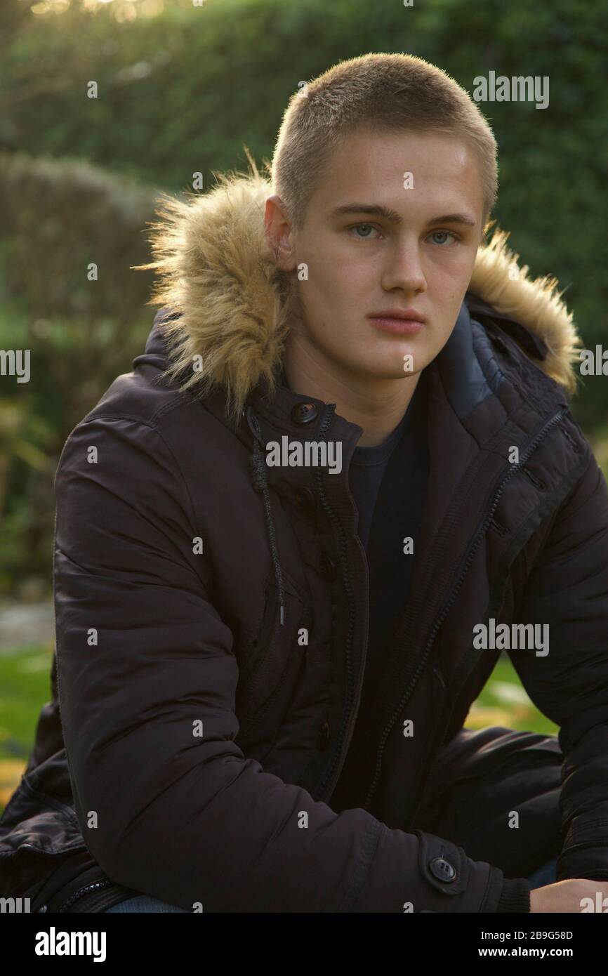 Portrait confident teenage boy in jacket with fur hood Stock Photo