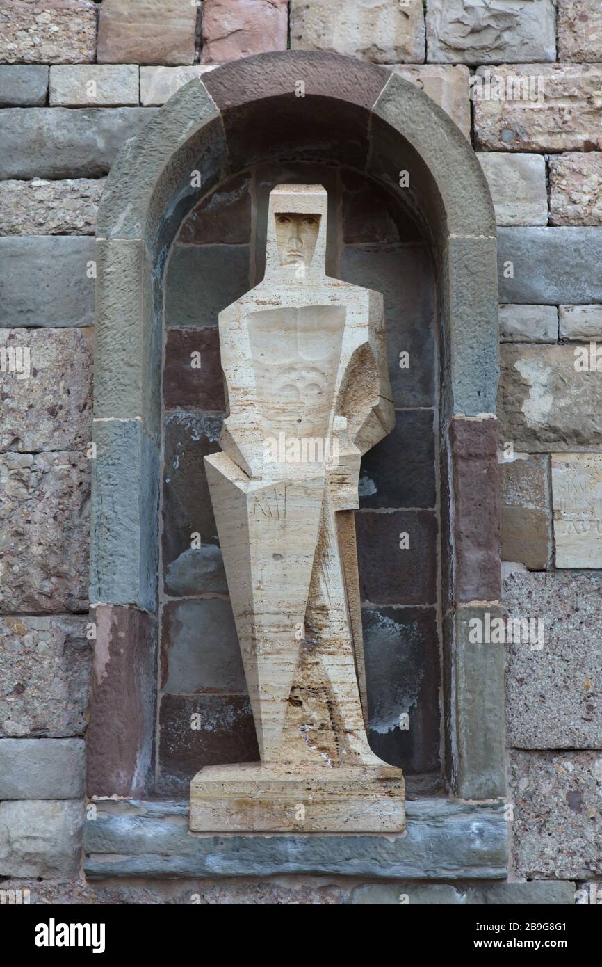 Statue of Saint George (San Jorge) designed by Spanish modernist sculptor Josep Maria Subirachs in front of the Montserrat Monastery (Monasterio de Montserrat) in the mountain massif near Barcelona, Catalonia, Spain. Stock Photo
