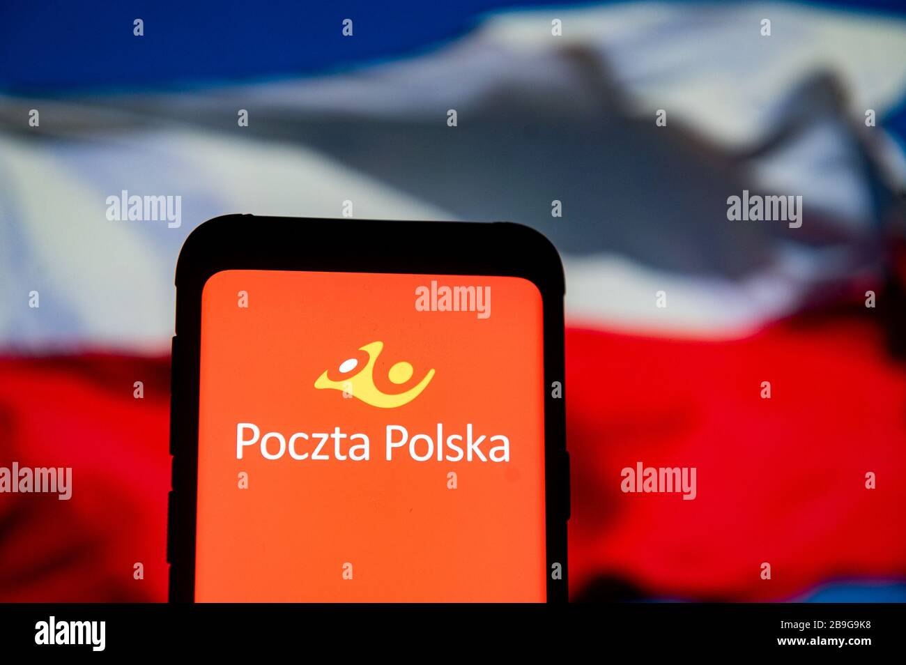 In this photo illustration a Poczta Polska (Polish Post) logo seen displayed on a smartphone.The Polish national flag is displayed as the background. Stock Photo
