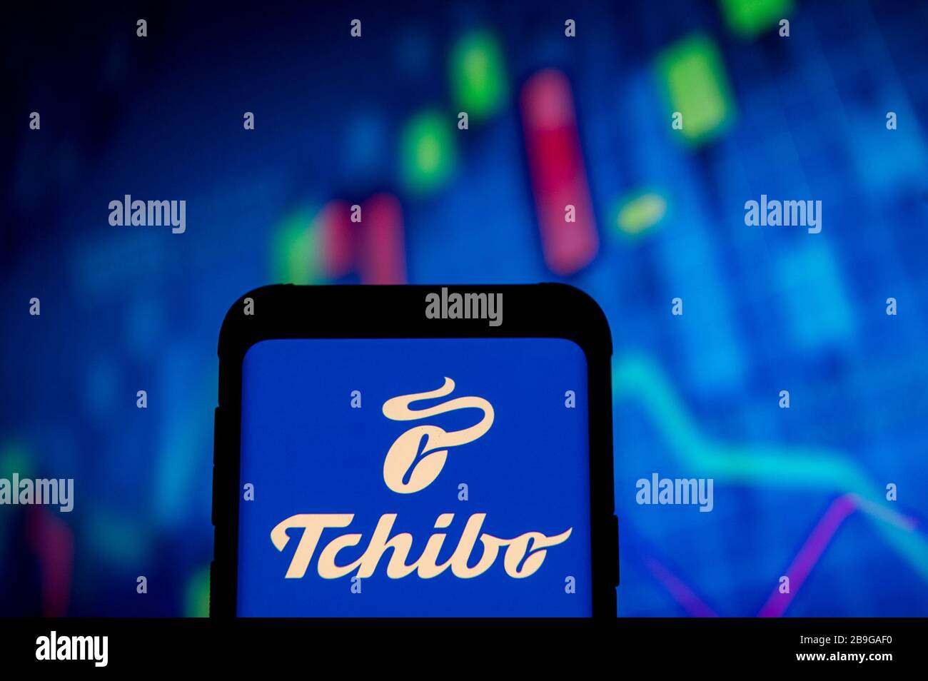 In this photo illustration a Tchibo logo seen displayed on a smartphone.A  stock market chart is being displayed as the background Stock Photo - Alamy