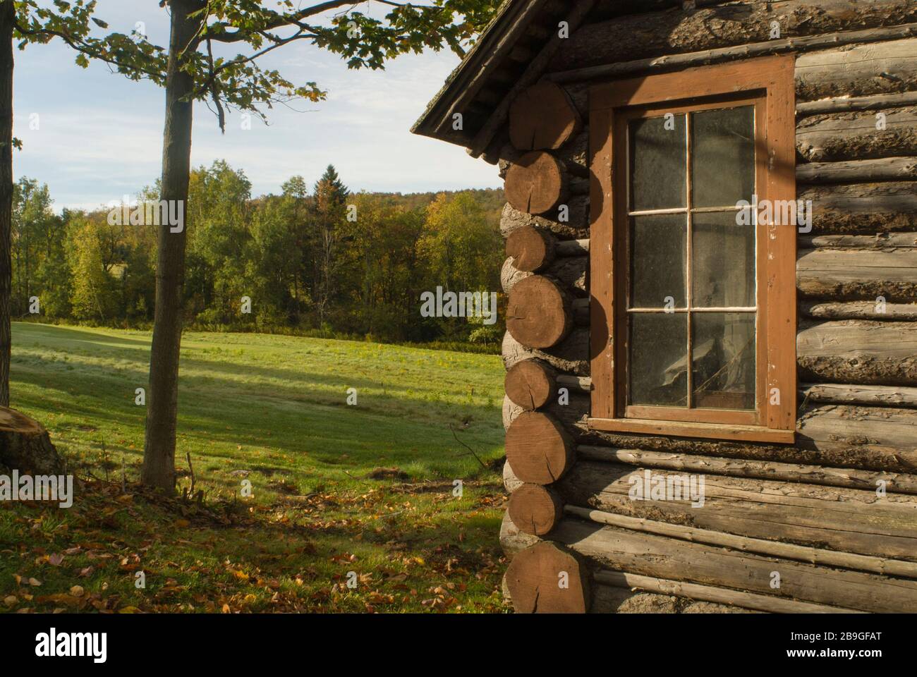 Log cabin & view of pasture & trees in early autumn Ripton, Vermont Stock Photo