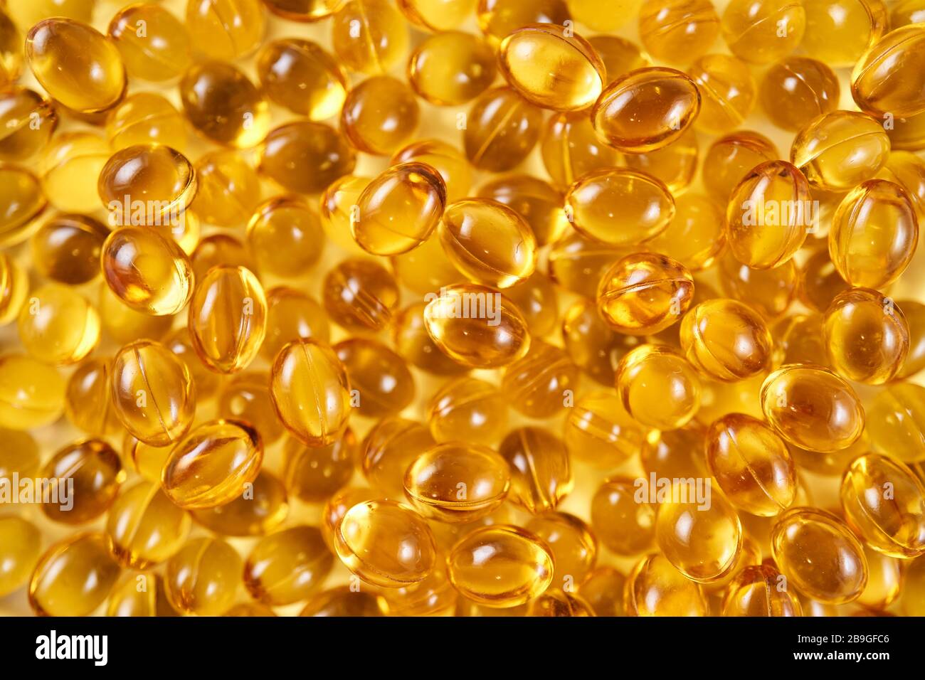Soft yellow gelatin vitamin D capsules (top view close up) Stock Photo