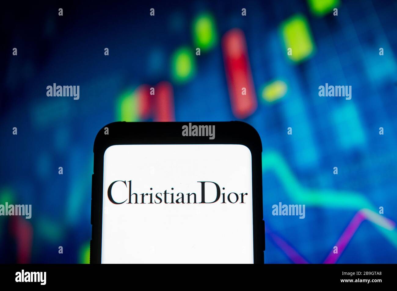 March 23, 2020, Poland: In this photo illustration a Christian Dior logo seen displayed on a smartphone..A stock market chart is being displayed as the background. (Credit Image: © Mateusz Slodkowski/SOPA Images via ZUMA Wire) Stock Photo